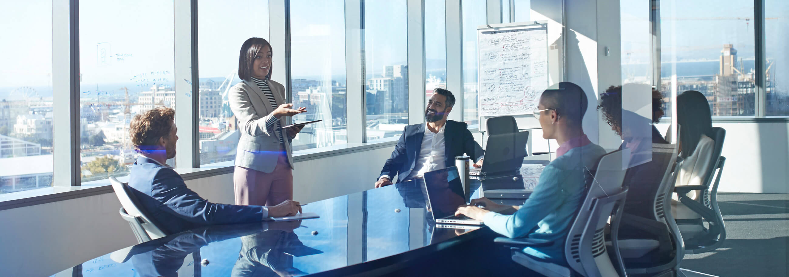 four collegues talking while holding coffee cups