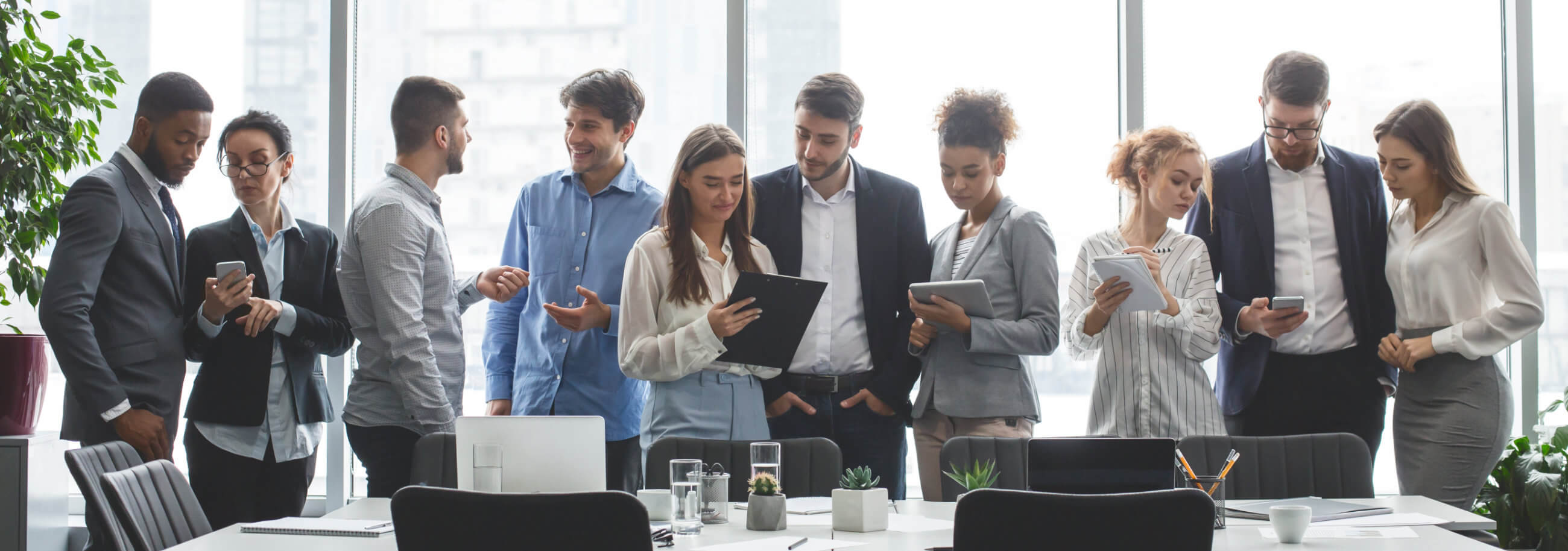 four collegues talking while holding coffee cups